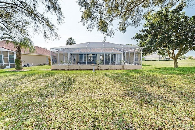 back of property featuring a lanai and a yard