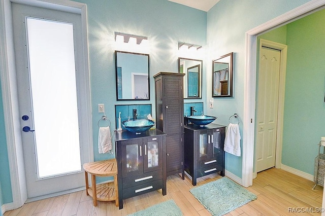 full bath with a sink and wood finished floors