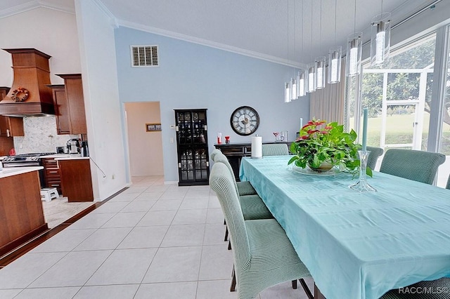 dining room featuring high vaulted ceiling, visible vents, crown molding, and light tile patterned flooring