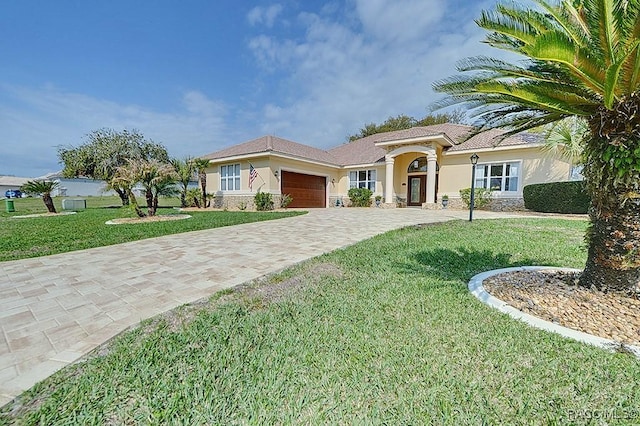 view of front of property with stone siding, an attached garage, decorative driveway, a front lawn, and stucco siding