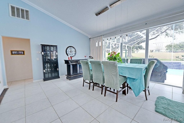 dining room with lofted ceiling, visible vents, ornamental molding, and light tile patterned flooring