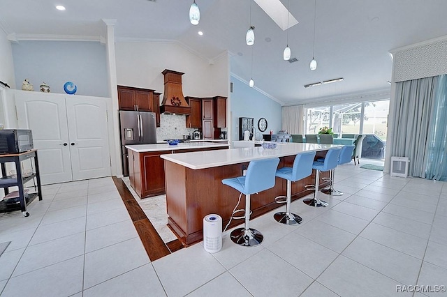 kitchen featuring ornamental molding, light countertops, a large island, and custom exhaust hood