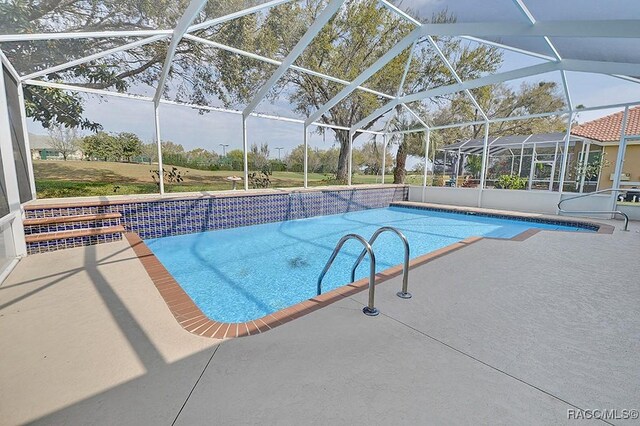 outdoor pool featuring a lanai and a patio area