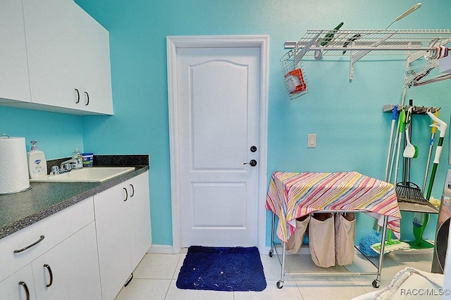 interior space featuring baseboards, a sink, and light tile patterned flooring