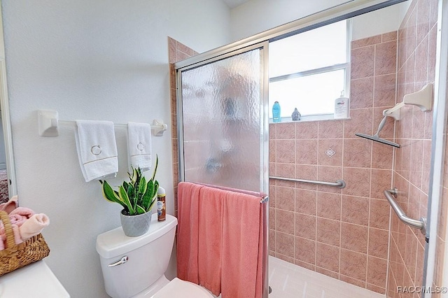 full bath featuring a stall shower and toilet