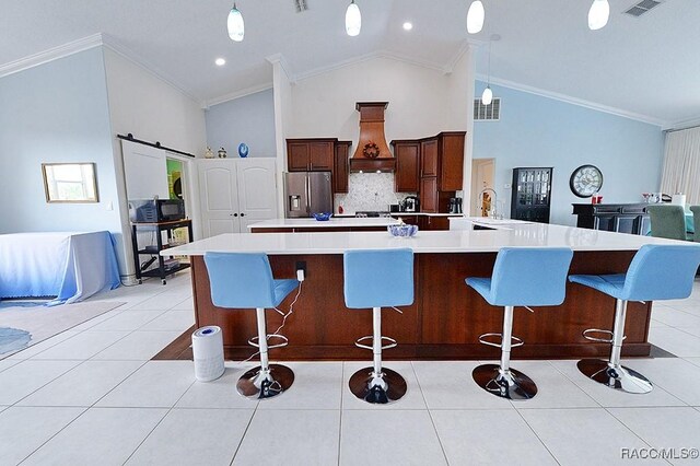 kitchen with stainless steel fridge, custom range hood, light tile patterned flooring, and a barn door