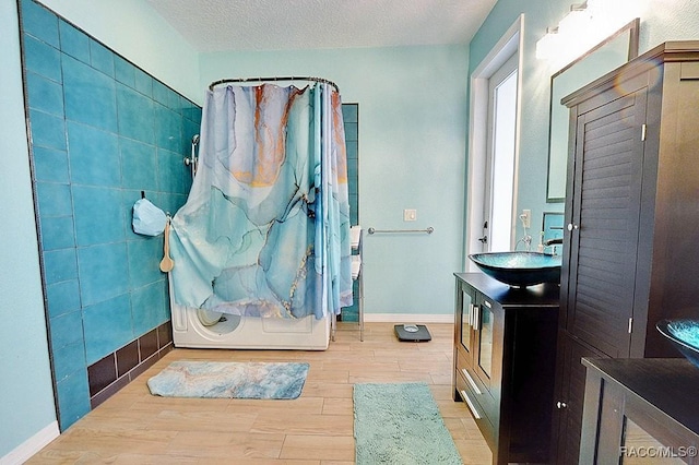 bathroom with vanity, a textured ceiling, a shower with shower curtain, and wood finished floors