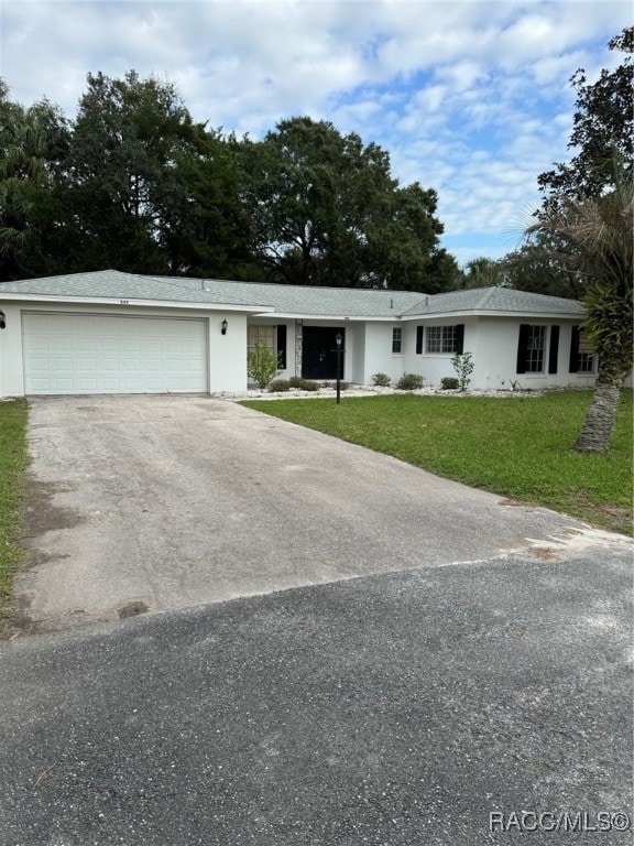 single story home featuring a garage and a front yard