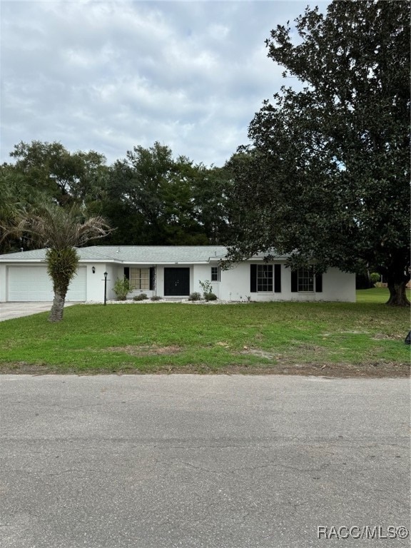 view of front of home with a garage and a front lawn