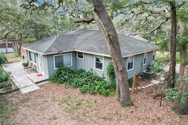 view of side of home with central AC unit and a patio