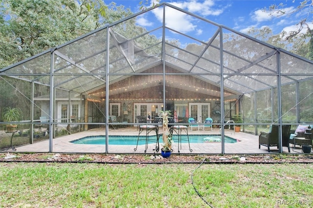 view of pool with glass enclosure, a patio, and french doors