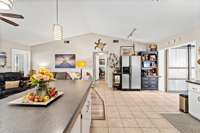 kitchen featuring pendant lighting, vaulted ceiling, ceiling fan, stainless steel fridge, and white cabinetry