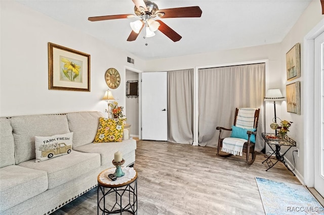 living room featuring wood-type flooring and ceiling fan