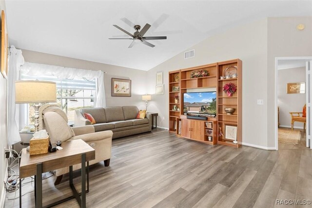 living room featuring hardwood / wood-style floors, vaulted ceiling, and ceiling fan