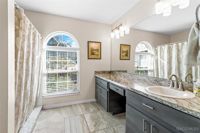 bathroom with a shower with shower curtain and vanity