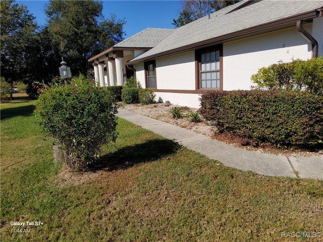 view of side of home with a lawn