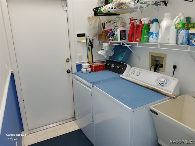 clothes washing area featuring separate washer and dryer and sink