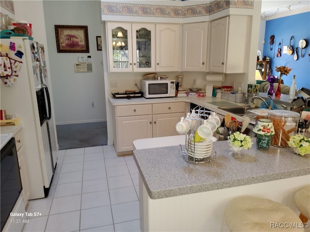 kitchen featuring kitchen peninsula, white appliances, light tile patterned flooring, and sink