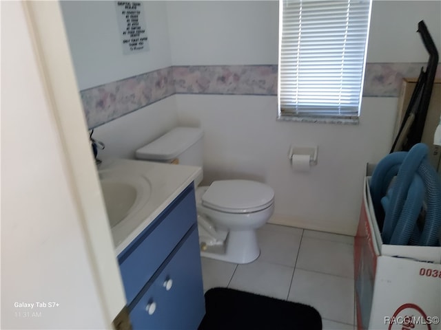 bathroom with tile patterned flooring, vanity, and toilet