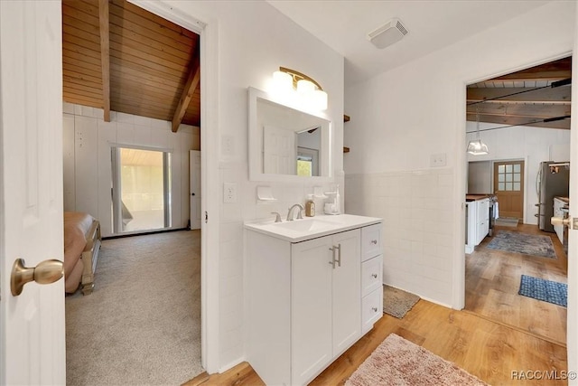 11615 N Caribee Pt, Inglis, FL 34449 - full bath featuring vanity, wooden ceiling with exposed beams, healthy amount of natural light, wood finished floors, and wainscoting