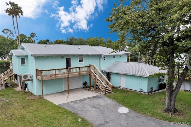 11615 N Caribee Pt, Inglis, FL 34449 - view of front of home featuring stairway, an attached garage, asphalt driveway, metal roof, and a front yard