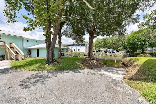 11615 N Caribee Pt, Inglis, FL 34449 - view of front facade with stairway, a water view, and a front lawn