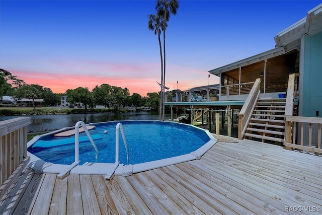 11615 N Caribee Pt, Inglis, FL 34449 - pool at dusk with stairway, a deck with water view, and a sunroom