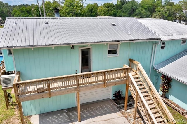 11615 N Caribee Pt, Inglis, FL 34449 - back of property with a deck, stairs, metal roof, a garage, and a cooling unit