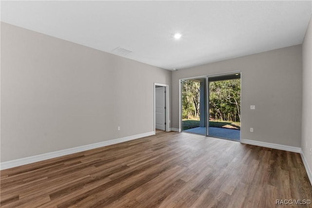 spare room featuring baseboards and wood finished floors