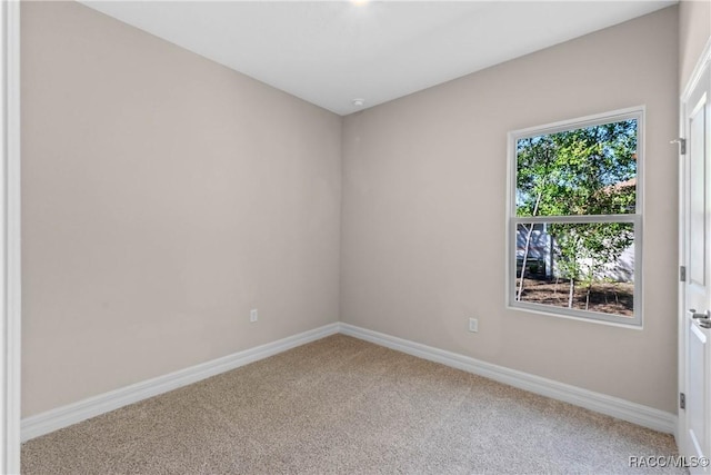 carpeted empty room with baseboards