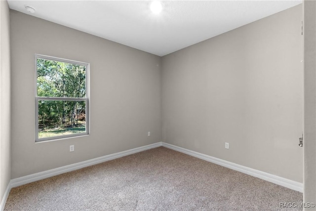 carpeted empty room with baseboards