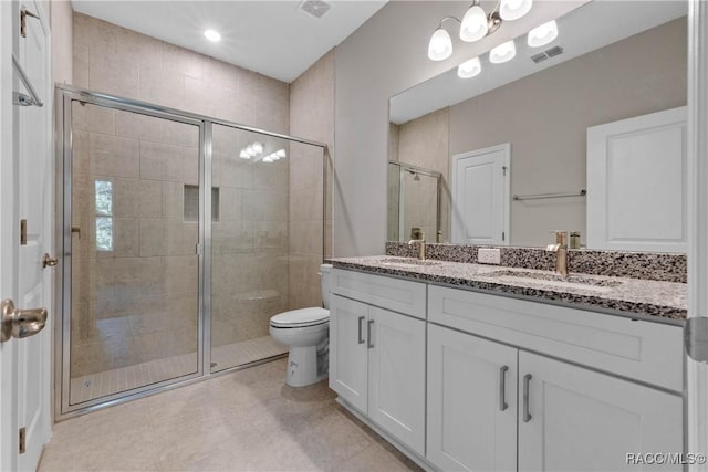 bathroom with toilet, a sink, visible vents, a shower stall, and double vanity