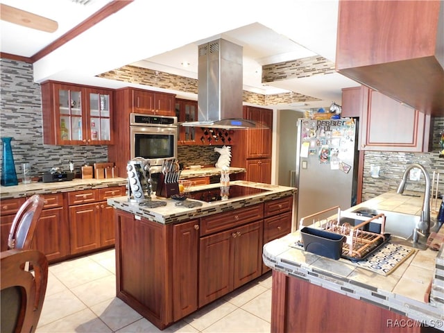 kitchen with decorative backsplash, island range hood, crown molding, and appliances with stainless steel finishes