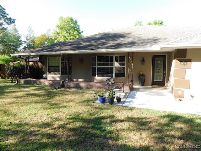 back of house featuring a lawn and a patio area