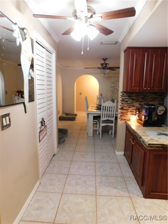 kitchen featuring decorative backsplash, light tile patterned floors, and ornamental molding