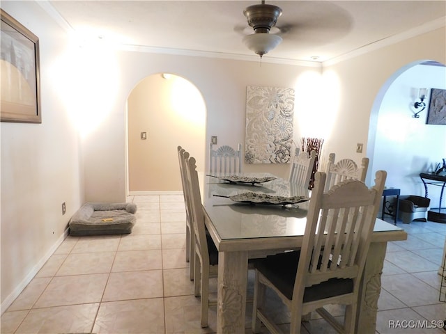 tiled dining area with ceiling fan and ornamental molding