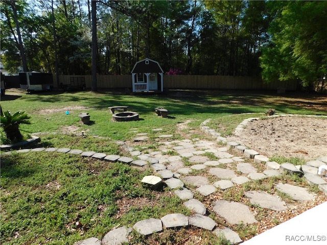 view of yard with a storage unit and an outdoor fire pit