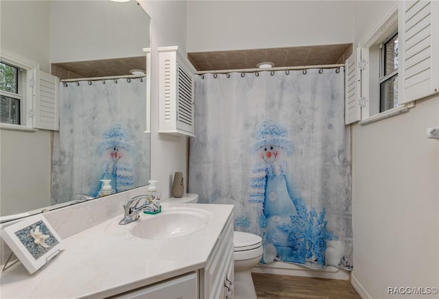 full bathroom with vanity, wood-type flooring, shower / tub combo, and toilet