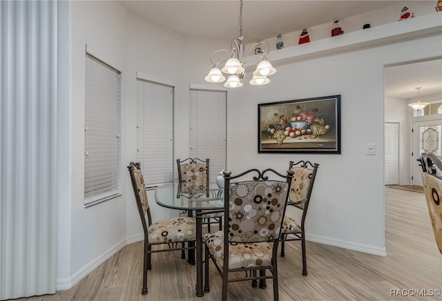 dining room featuring light wood-type flooring and a notable chandelier