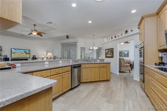 kitchen with light brown cabinets, hanging light fixtures, stainless steel appliances, light hardwood / wood-style flooring, and ceiling fan with notable chandelier