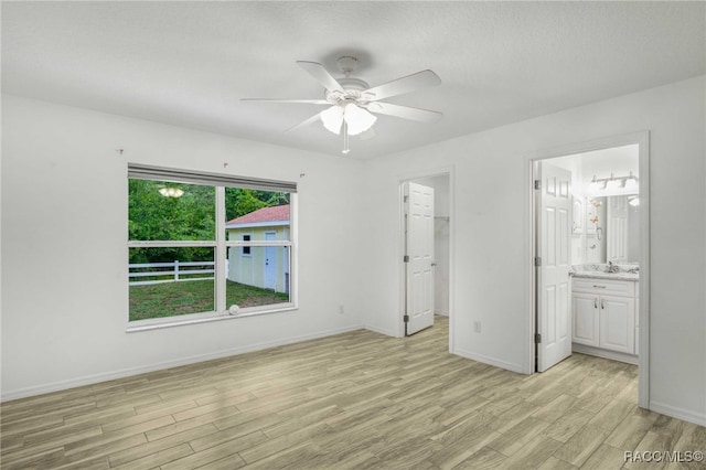 632 S Arlene Ave, Inverness, FL 34453 - unfurnished bedroom with light wood finished floors, a spacious closet, ensuite bathroom, a ceiling fan, and a closet