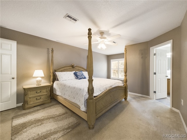 bedroom featuring light carpet, a textured ceiling, and ceiling fan