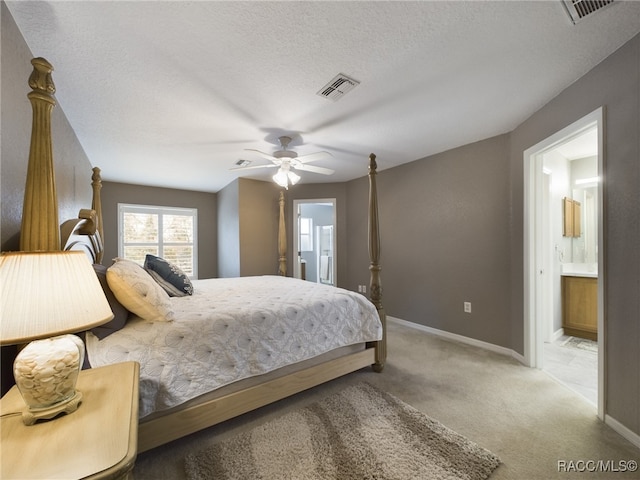 bedroom featuring carpet flooring, connected bathroom, a textured ceiling, and ceiling fan