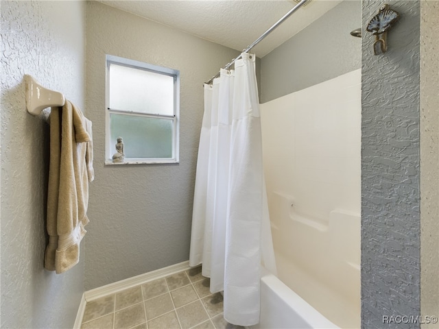 bathroom with shower / bathtub combination with curtain and a textured ceiling