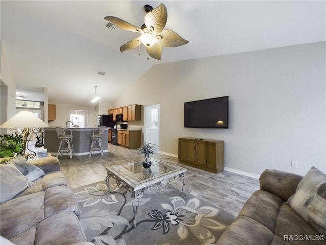 living room featuring ceiling fan and vaulted ceiling