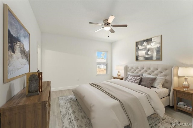 bedroom with ceiling fan, light wood-style flooring, and baseboards