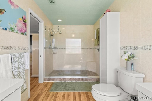 834 E Boston St, Hernando, FL 34442 - bathroom with tile walls, a shower stall, vanity, toilet, and wood finished floors