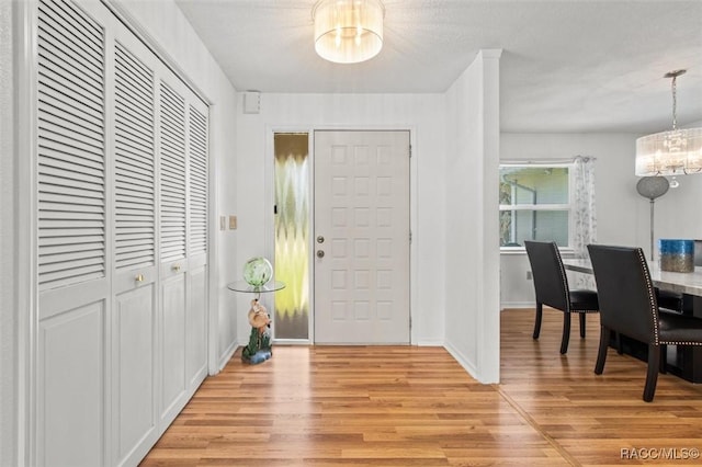 834 E Boston St, Hernando, FL 34442 - entrance foyer with a chandelier, light wood-style flooring, and baseboards