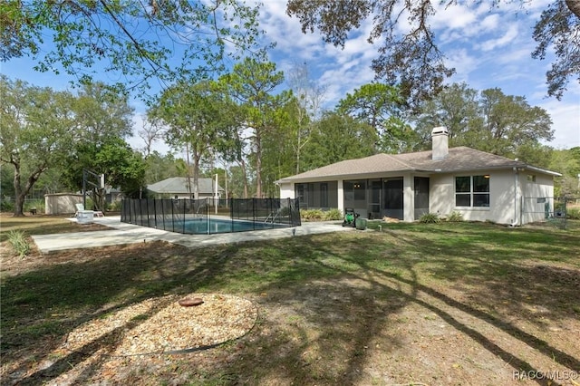 view of yard featuring a sunroom, a fenced in pool, and a patio area