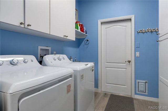 laundry room with light wood-type flooring, cabinets, and independent washer and dryer